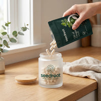Refilling the Seedroot bamboo lid glass jar with capsules poured from a Seedroot pouch
