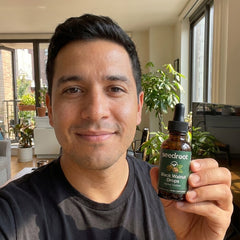 Man holding the Seedroot Black Walnut Drops amber dropper bottle