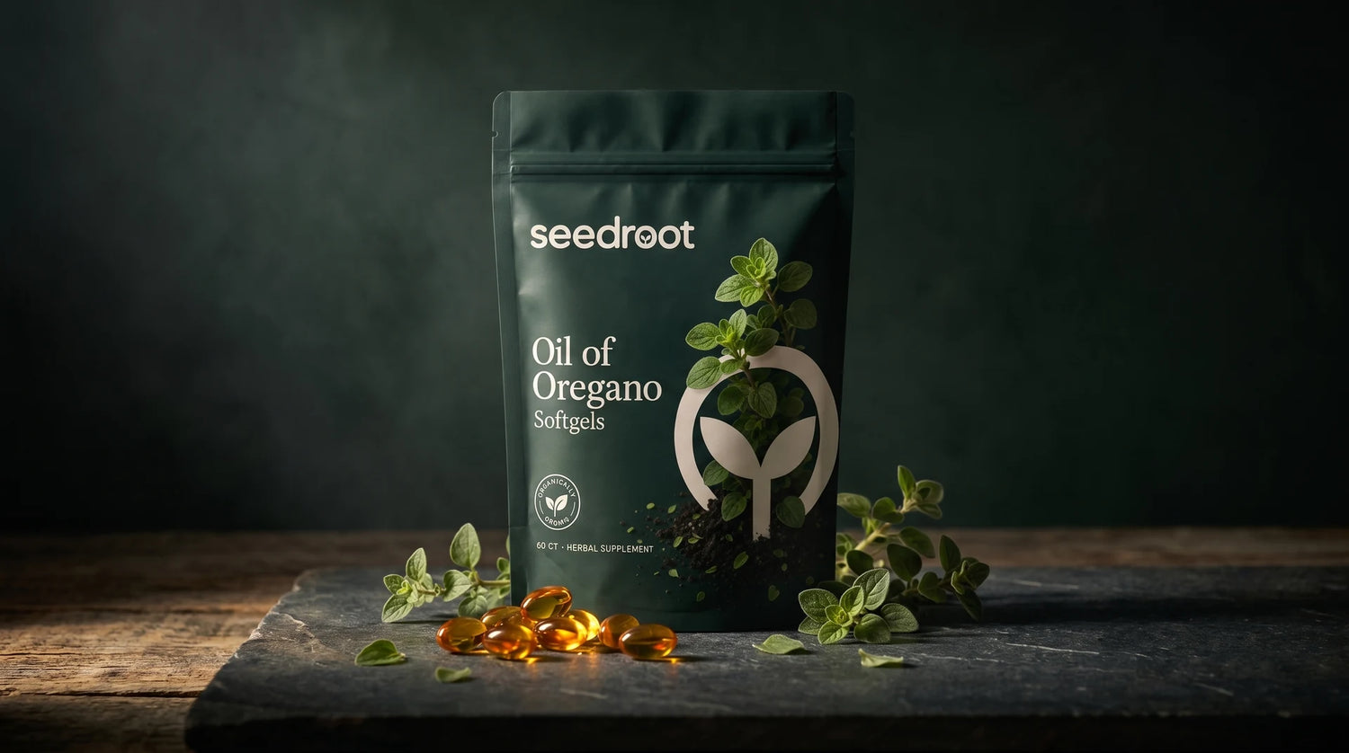Cinematic still-life of Seedroot Oil of Oregano Softgels pouch with golden softgels and fresh oregano on dark stone